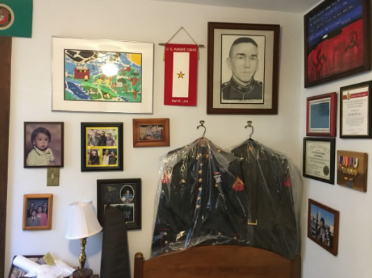 Karl Linn's formal dress blues hang at the head of his bed with other awards and mementos.